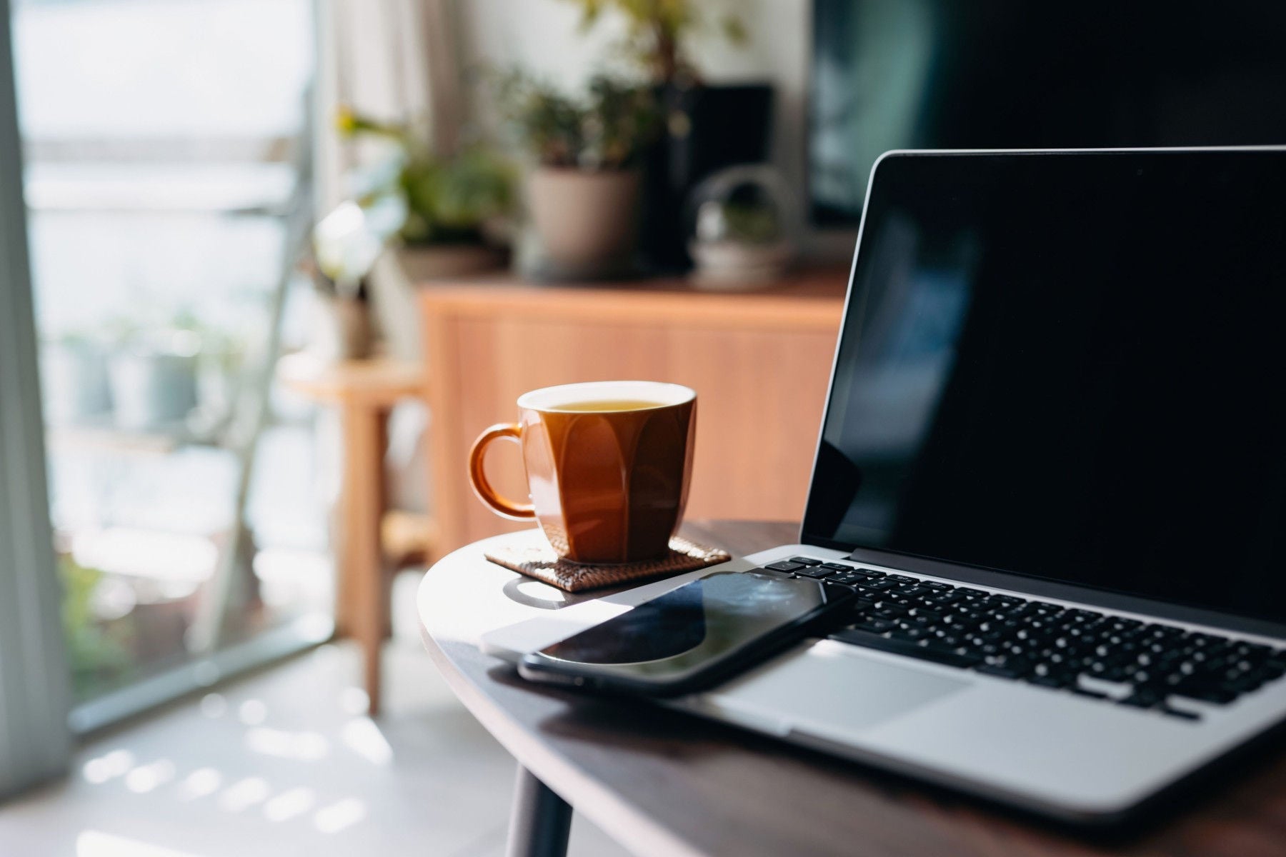 Laptop und Kaffeetasse auf Tisch