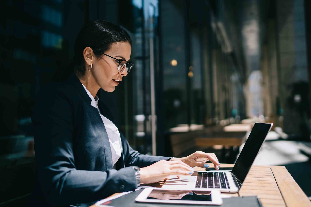 Side view of serious female lawyer working online