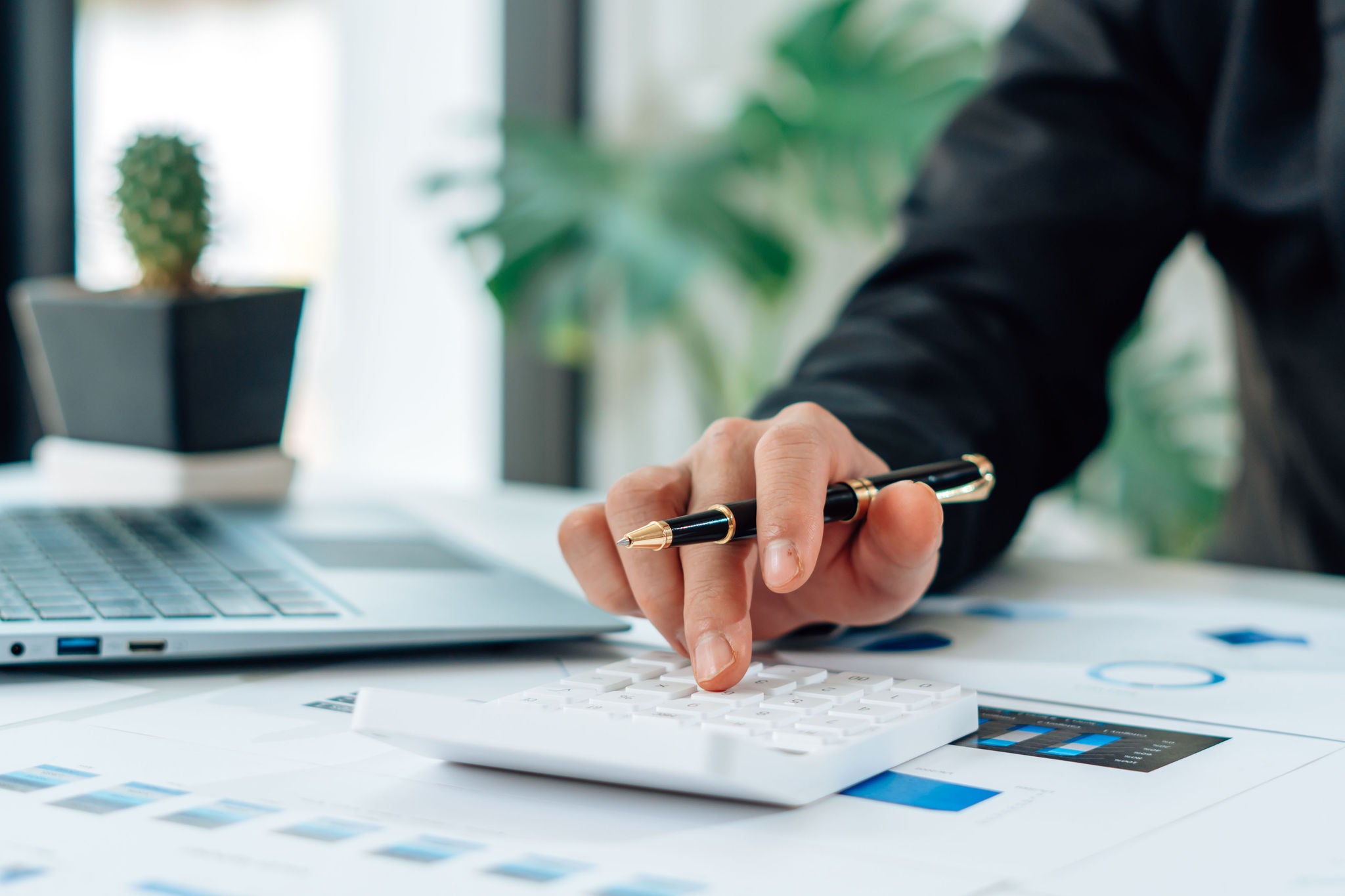 Business accounting concept, Business man using calculator with computer laptop, budget and loan paper in office.