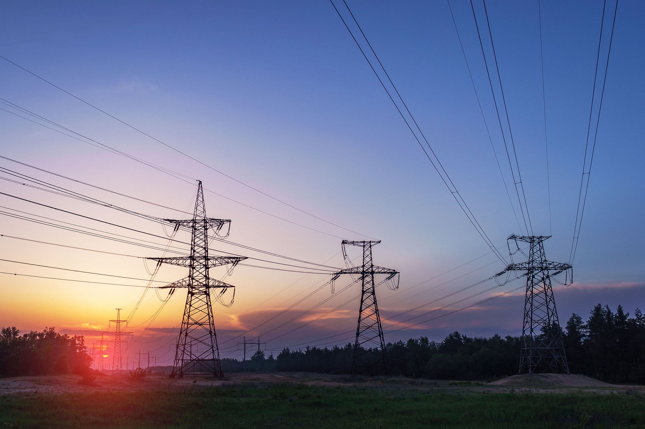 High-voltage power lines at sunset electricity distribution station 