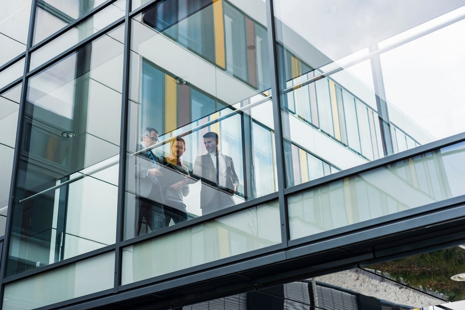 Drei Businessmänner gehen über eine Brücke im Office