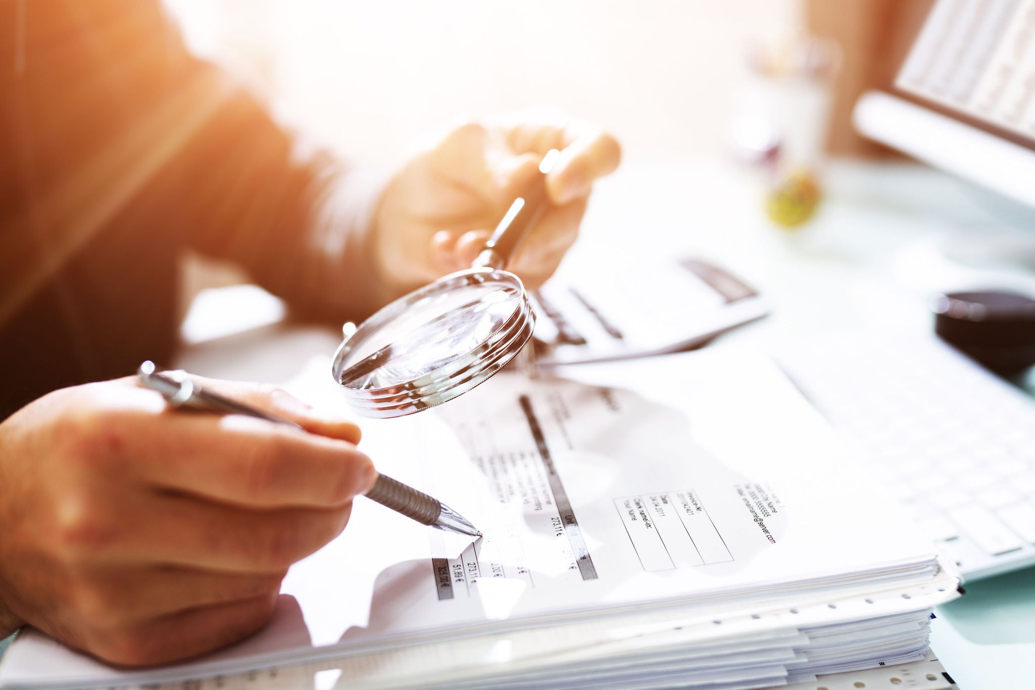 Audit And Fraud Investigation. Auditor Using Magnifying Glass On Document