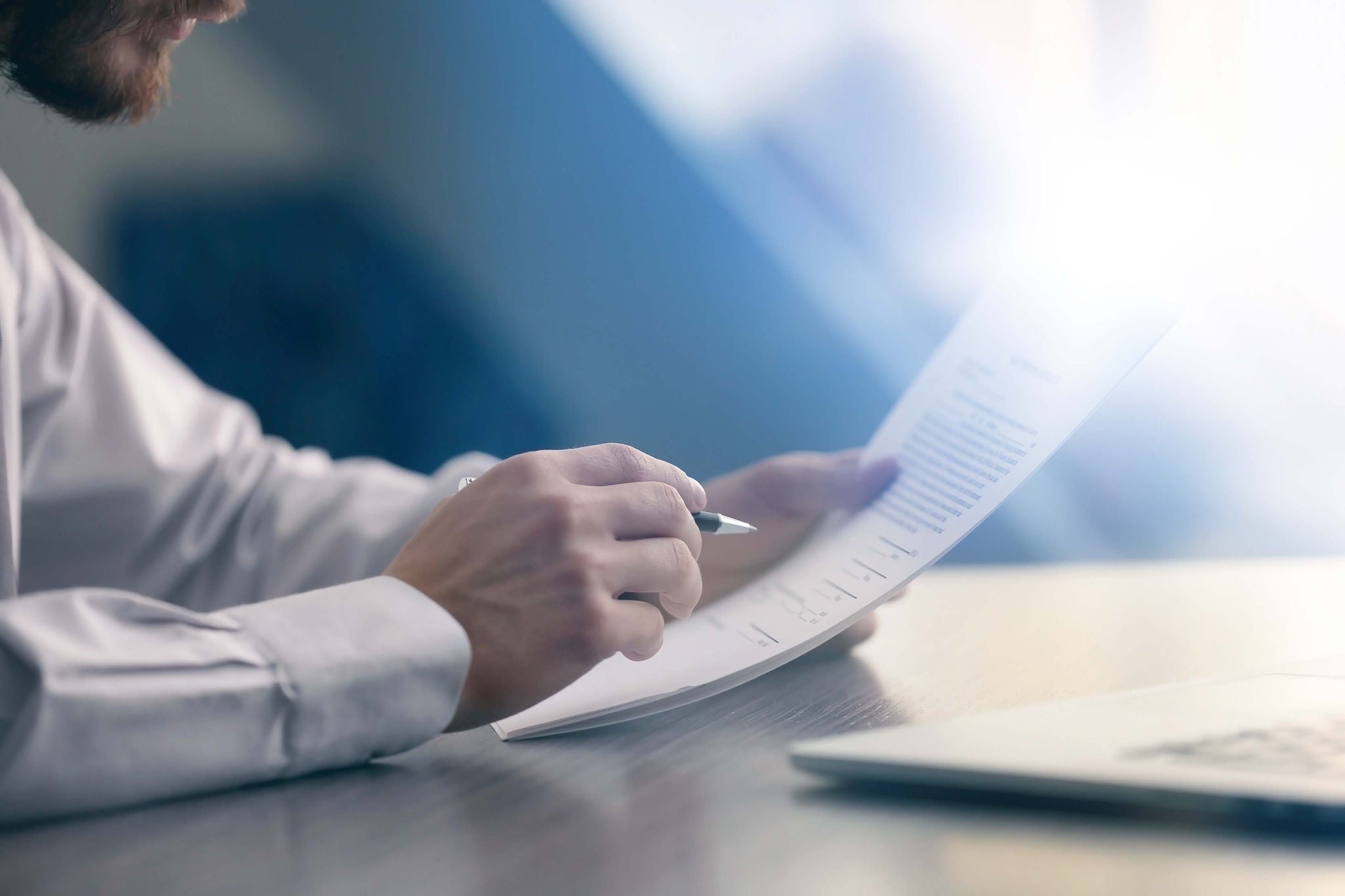 Businessman reading documents at table in office