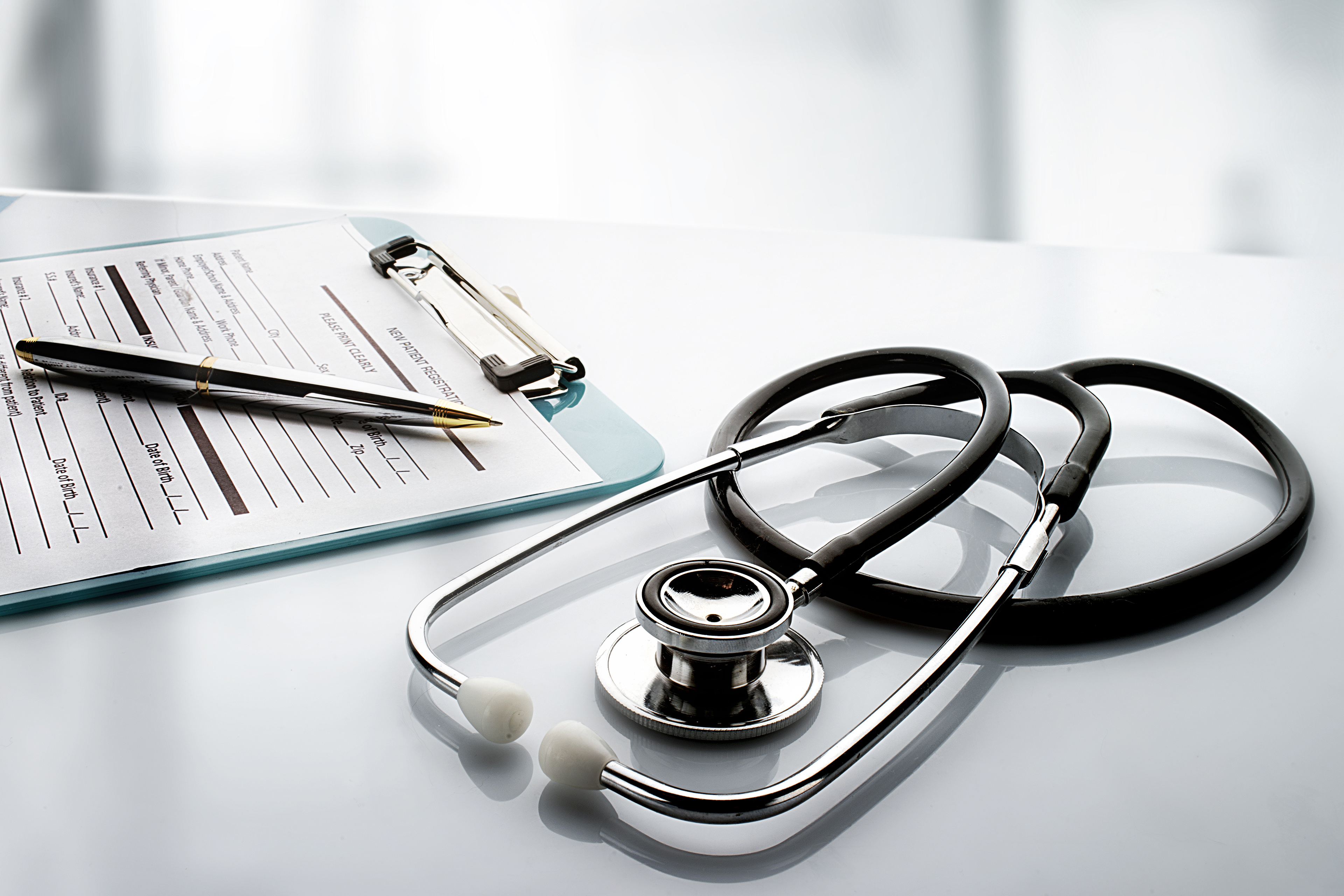 Stethoskop liegt neben Dokument auf Tisch